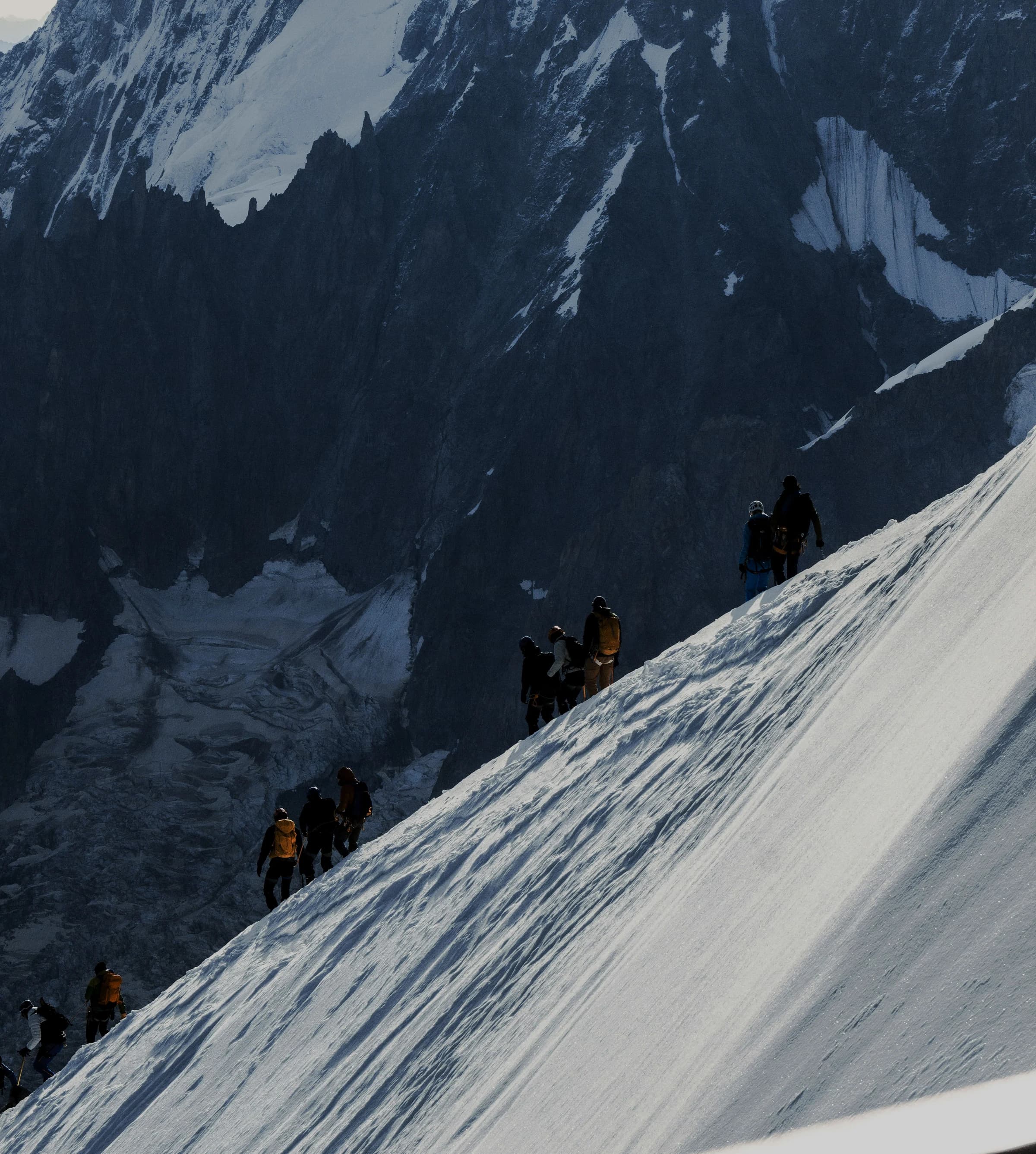 Une cordée d’alpinistes progresse sur une pente enneigée des Alpes